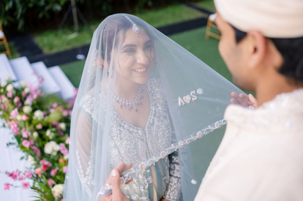 Bride under a custom wedding veil embroidered with the couple's monogram during a Pune ceremony